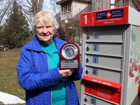 Joyce Bowls displays a clock she received from Canada Post commemorating the 100 consecutive years her family delivered mail on the same rural route in the Kent Bridge area. (Ellwood Shreve/Chatham Daily News)