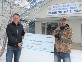 Local MLA Peter Guthrie and the Veteran Hunters’ Todd Hisey recognize a contribution to the non-profit from the province’s COVID-19 Community Funding program on March 25. Patrick Gibson/Cochrane Times