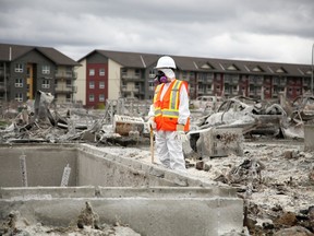 Team Rubicon member pauses between sifting through the remains of a home on Prospect Drive in Fort McMurray's Timberlea neighbourhood on June 12, 2016. Olivia Condon/ Fort McMurray Today/ Postmedia Network