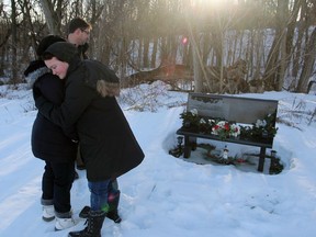 The Garrah family, Lori, Dawn and John, at Deidra Garrah’s grave at St. Patrick’s Cemetery in Sydenham on Thursday.