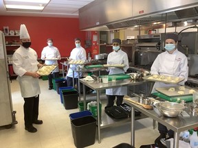 St. Lawrence College chef professor Gary Appleton, left, and first-year culinary skills and culinary Management students Sara Northcott, Cheryl Hanna, Simranjit Kaur and Peyton Sousa, show off some of the prepared individually packaged meals for patrons of Martha's Table in Kingston.
