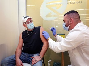 Pharmacist Adam Doyle administers a dose of the AstraZeneca COVID-19 vaccine to Perry Murphy at Shoppers Drug Mart in the Kingslake Plaza in Kingston on Saturday.