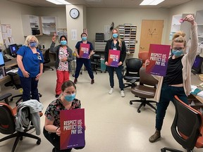 Staff at Kingston Health Sciences Centre and members of CUPE 1974, from left, Jennifer Davis, Shelly Cucuinni, Rebeka Jehan, Caitlin Empty, Keri Beltrami and Bri Elliot, with signs for their "Respect Us. Protect Us. Pay Us" work action on International Women's Day in Kingston on Monday.