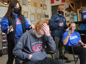 Andrea McNeil, left, shaves the head of Kingston Canadians player Jack White while Cooper Salter has his head shaved by McNeil's son, Owen Basich, during a fundraising event just west of Kingston on Sunday to help cover expenses after McNeil's cancer diagnosis.
