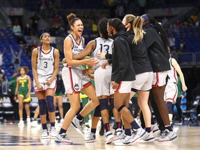 Kingston's Aaliyah Edwards (3) joins her University of Connecticut Huskies teammates to celebrate their NCAA women's basketball tournament 69-67 quarter-final win over the Baylor Lady Bears on Monday March 29, 2021, at the Alamodome in San Antonio, Texas.