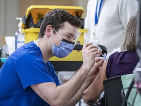 Queen's University medical student Adam Birosh administers a COVID-19 vaccination to a Kingston Health Sciences Centre staff member at a Queen's School of Medicine student-run vaccination clinic in an undated photo.