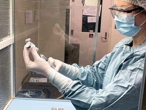Sam Moreau a Registered Pharmacy Technician at the Kirkland Lake site filling an IV under the IV Compound Hood. This device keeps the tools sterile while being prepared.