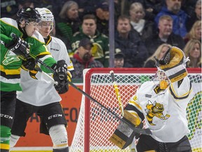 Knights forward Connor McMichael lunges to try to deflect a high shot past Sting goalie Benjamin Gaudreau while being checked by Eric Hjorth during the first period of their OHL game Friday March 6, 2020, at Budweiser Gardens. (Mike Hensen/The London Free Press)