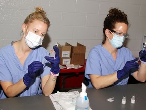 Kristie Dulac (left) and Amy Warlich, Pembroke Regional Hospital pharmacy technicians, fill syringes with doses of the COVID-19 vaccine during a public clinic at the Pembroke Memorial Centre March 12. It was the first public clinic in Pembroke and approximately 600 people received their first dose of vaccine.