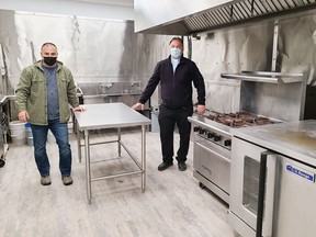 Jerry Novack, executive director of The Grind Pembroke, and Rev. Deacon Adrien Chaput, a director on The Grind Pembroke board of directors, are smiling under those masks because they are close to being able to prepare lunches for clients in this commercial kitchen at the Grind's new location at the former fire hall on Victoria Street.