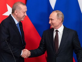 Russian President Vladimir Putin and Turkish President Tayyip Erdogan shake hands during a news conference following their talks in Moscow in March 2020.