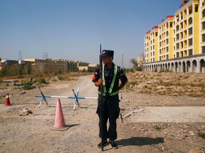 A Chinese police officer takes his position by the road near what is officially called a vocational education centre in Yining in Xinjiang Uighur Autonomous Region, China, in September 2018.