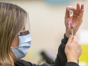 Jill Seara, a public health nurse loads a 1ml syringe with the Pfiizer COVID-19 vaccine at the Caradoc community centre in Mt. Brydges. Mike Hensen/Postmedia Network