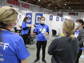 Nadine Neve, with Bluewater Health, speaks to staff Friday before the doors open at the COVID-19 immunization clinic at the Point Edward Memorial Arena.
