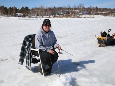 Sheryl Bourgeois enjoys the weather while ice fishing with her husband, Remi, on Ramsey Lake in Sudbury, Ont. on Tuesday March 9, 2021. John Lappa/Sudbury Star/Postmedia Network
