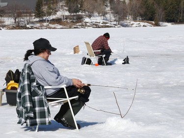 Sheryl Bourgeois enjoys the weather while ice fishing with her husband, Remi, on Ramsey Lake in Sudbury, Ont. on Tuesday March 9, 2021. John Lappa/Sudbury Star/Postmedia Network