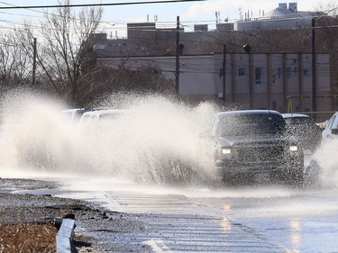 Motorists attempt to navigate through a large puddle on the Kingsway in Sudbury, Ont. on Thursday March 11, 2021. John Lappa/Sudbury Star/Postmedia Network