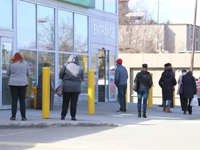 People line up to shop for groceries at Food Basics on Regent Street on March 12.