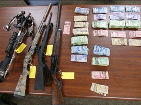 Pictured are the weapons and cash recovered during a drug raid in Sudbury on March 17. OPP photo