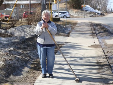 Lydia Pischlar takes a break from sweeping a sidewalk in front of her home in Sudbury, Ont. on Monday March 22, 2021. John Lappa/Sudbury Star/Postmedia Network