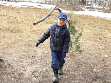Andy Klein, 6, balances a branch on his head while visiting Fielding Memorial Park in Greater Sudbury, Ont. with his family on Tuesday March 23, 2021. John Lappa/Sudbury Star/Postmedia Network