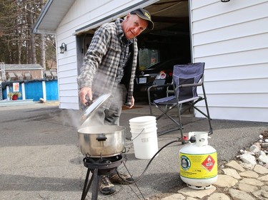 Daniel Boisvert, of Naughton, Ont., boils saps from a neighbour's maple tree so he can make maple syrup on Tuesday March 23, 2021. John Lappa/Sudbury Star/Postmedia Network