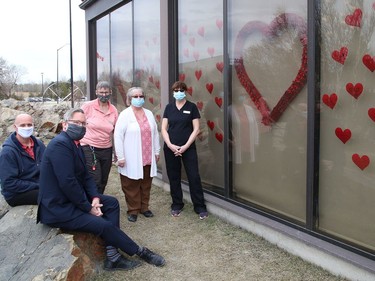Some of the Travelway Inn staff in Sudbury, Ont. stand near a window at the hotel that features hearts on Wednesday March 24, 2021. The Spread The Love campaign, which was initiated by Travelway Inn, was created to salute health care workers. John Lappa/Sudbury Star/Postmedia Network