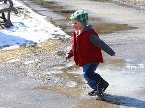 Two-year-old Nolan Sarazin has fun splashing in ice-covered puddles at Bell Park in Sudbury, Ont. on Monday March 29, 2021. John Lappa/Sudbury Star/Postmedia Network