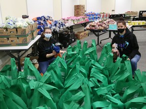 Stephanie Gerrard, left, and Lynne Ethier, of Our Children, Our Future, prepare grocery bags for 100 vulnerable families in Sudbury, Ont. on Tuesday March 30, 2021. These bags of food will provide an Easter dinner and Easter eggs for the kids for the Easter weekend. These are families with young children who have been struggling with financial hardship due to the pandemic. The food will directly impact over 400 individuals. Our Children, Our Future staff will deliver the food March 31 and April 1. John Lappa/Sudbury Star/Postmedia Network