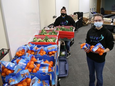 Lynne Ethier, left, and Stephanie Gerrard, of Our Children, Our Future, prepare grocery bags for 100 vulnerable families in Sudbury, Ont. on Tuesday March 30, 2021. These bags of food will provide an Easter dinner and Easter eggs for the kids for the Easter weekend. These are families with young children who have been struggling with financial hardship due to the pandemic. The food will directly impact over 400 individuals. Our Children, Our Future staff will deliver the food March 31 and April 1. John Lappa/Sudbury Star/Postmedia Network