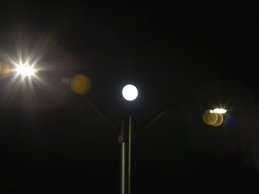 The moon rises between street lights in Naughton, Ont. on Monday March 29, 2021. John Lappa/Sudbury Star/Postmedia Network