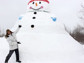 Michel Campeau displays the 25-foot high snowman he constructed in his yard on Carrigan Road in the Connaught area. He built it for his grandchildren but it has become an attraction for curious passersby and even visitors who occasionally stop by to take photos. 

RICHA BHOSALE/The Daily Press