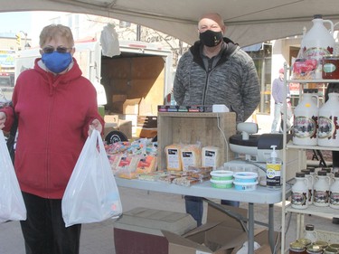 Solange Croaker visited the mini farmers' market held in Downtown Timmins on Saturday and came away with a few purchases. Alain Larocque, owner of Caffeination, was among the vendors, selling locally produced cheeses along with meat products from Graham Acres farm.

RON GRECH/The Daily Press
