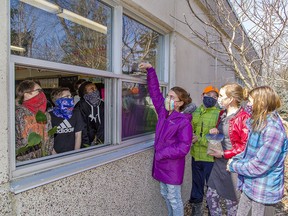 Rachel Brown adds birdseed to the window feeder at Port Rowan Elementary School on March 8. he Long Point Biosphere Reserve has provided FeederWatch kits to 50 classrooms in Haldimand and Norfolk counties. Classmates with her outside are Josh Hunt, Joelle Plumley and Avery Block (right). Brian Thompson/Postmedia Network