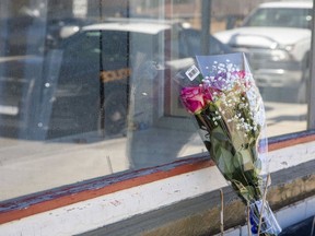 Flowers were placed Friday near the entrance to the West Lorne apartment where April Calcutt died in a fire last week. Please see the story on page A4. 
Derek Ruttan/The London Free Press/Postmedia Network