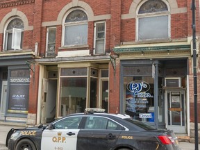 An OPP officer guards the scene of a fire in West Lorne where human remains were found after a fire in an upper apartment at 238 Graham St. Mike Hensen/Postmedia Network