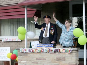 Exeter's Murray Greene and his daughter Bonnie LaFond wave March 23 as a drive-by parade passes Greene's house to mark his 100th birthday.