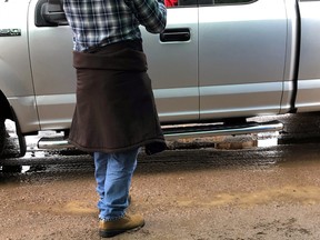 Lions Club member Kevin Topham takes a Do-it-Yourself Pancake Breakfast kit to a waiting customer.
Sue Oshell Photo