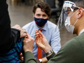 Prime Minister Justin Trudeau watches as nurse Thi Nguyen gives a COVID-19 vaccination at a clinic, as efforts continue to help slow the spread of the coronavirus disease, in Ottawa March 30, 2021. PHOTO BY BLAIR GABLE /REUTERS