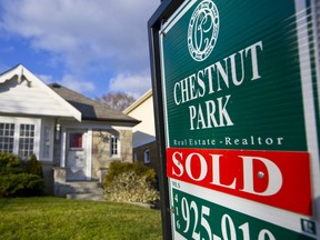 A "Sold" sign stands outside an existing home for sale in Toronto.