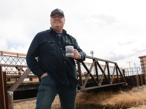 Tim Lowing stands next to the Nose Creek Bridge with mug in hand. The mug is being sold through Lowing's online photography store, with proceeds being donated to the Airdrie POWER Women's Shelter.