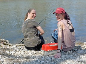 Tari Barnes, left, and Chloe Foster enjoy a warm spring day last week in Gibbons Park, finding a perfect spot to fish along the Thames River.
(BARBARA TAYLOR/Postmedia Network)
