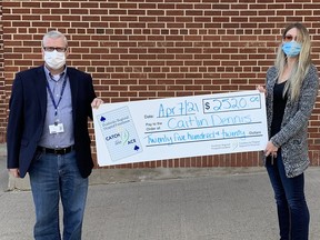 Pembroke Regional Hospital Foundation Executive Director Roger Martin presents Caitlin Dennis with her prize of $2,520 as the week #7 winner of the PRHF Catch the Ace online progressive jackpot lottery.