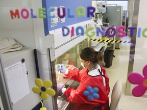 Medical laboratory technologist Danielle Lalonde works in Belleville General Hospital's medical microbiology laboratory Tuesday, Aug. 25, 2020. Hospital teams on Thursday were caring for a record number of inpatients with COVID-19, two of them younger than age 40.