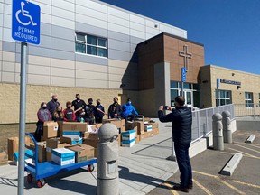 Students from St. Veronica School stand among boxes of donations gathered for the Airdrie Food Bank.