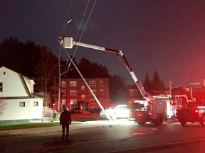 Hydro workers free a toppled pole from power lines at Keziah Court, off the Kingsway, after a vehicle crashed into the stanchion around midnight on Sunday.