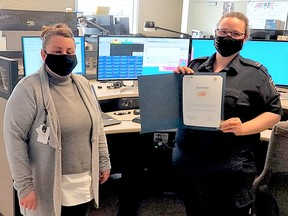 Timmins Police Service 9-1-1 Communications Operator Chantal Boudreau, right, receives a certificate, recognizing her efforts to calm dad-to-be down during a Feb. 19 call, from Timmins Police Service 9-1-1 Liaison and Policy Officer Jenn Scott, during a ceremony Thursday afternoon. SUBMITTED PHOTO