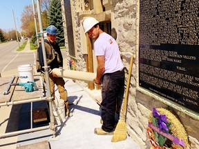 Employees of Robertson Restoration in Brantford cart away deteriorated stonework from the Norfolk War Memorial on Norfolk Street North in Simcoe. The $77,700 repair job now underway will arrest deterioration of the entrance facing onto Norfolk Street North. At left is Thomas Klak while at right is Hayden Robertson. – Monte Sonnenberg
