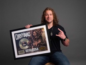 Cory Marks pictured with a plaque commemorating the Gold certification for his single, 'Outlaws & Outsiders.' Supplied Photo