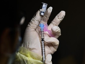 A pharmacist technician fills the Pfizer-BioNTech COVID-19 mRNA vaccine at a vaccine clinic during the COVID-19 pandemic in Toronto.